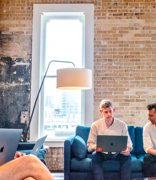 Three men working on computers together